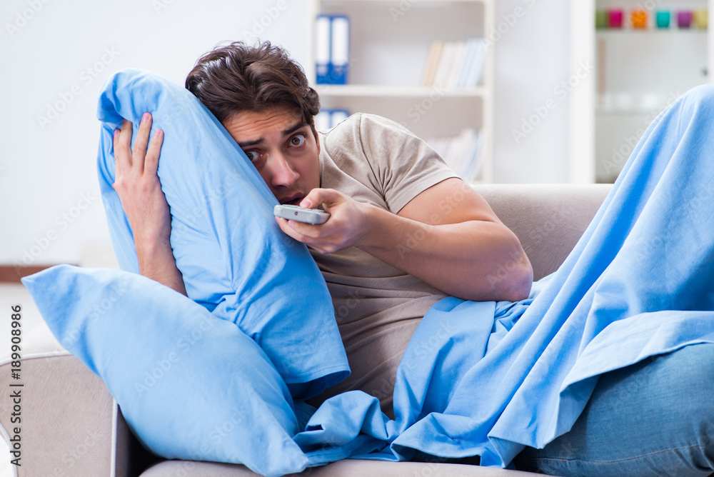 Man watching tv from bed holding remote control unit Man watching tv from bed holding remote control unit