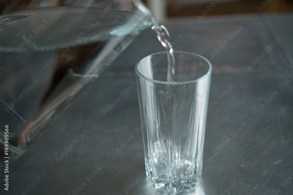 pouring water from a pitcher into a glass pouring water from a pitcher into a glass