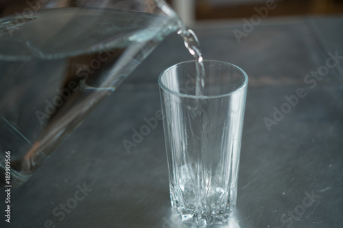 pouring water from a pitcher into a glass