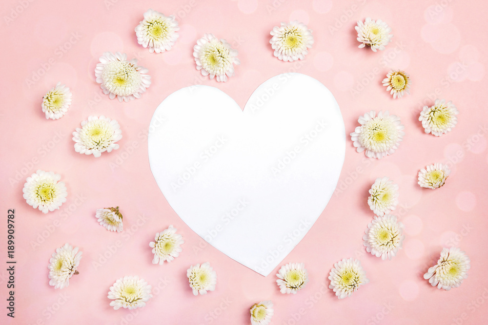 Heart-card with small chrysanthemum flowers on pink background. Place for text.
