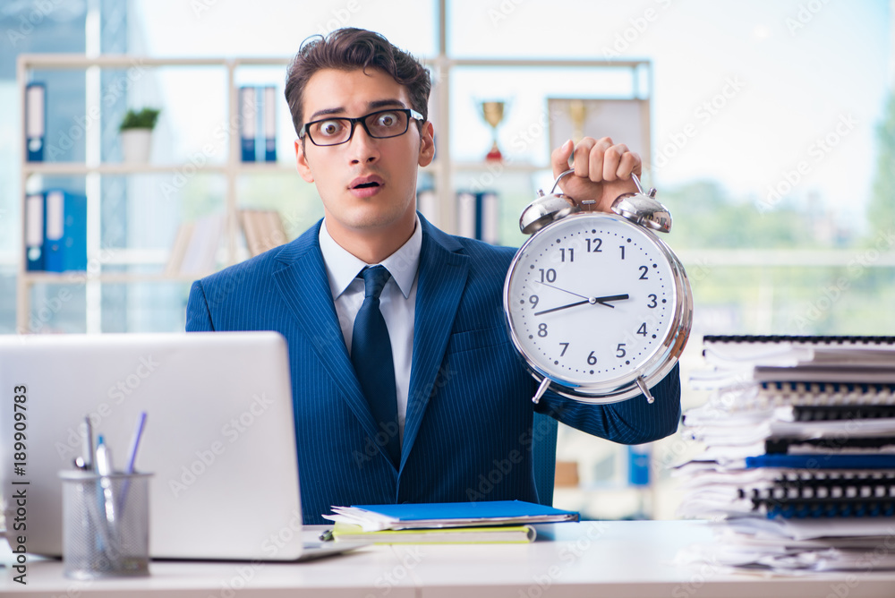 Businessman with giant clock failing to meet deadlines and missi Businessman with giant clock failing to meet deadlines and missi