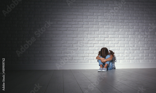 upset sad sad child girl in stress cries at an empty dark wall