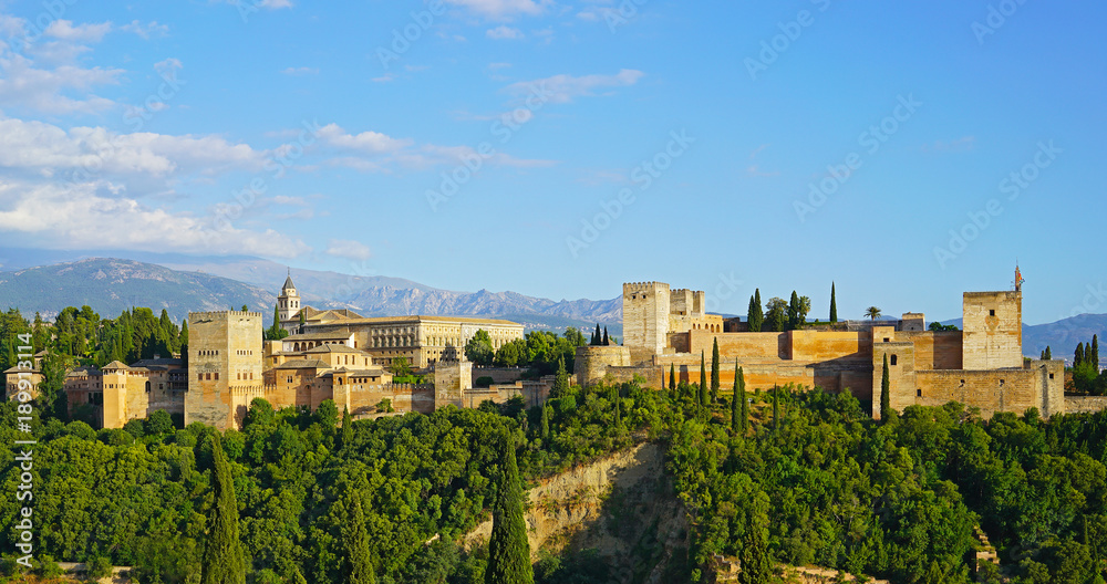 The Alhambra palace and fortress at sunrise hour, Granada, Spain. Ancient Arabic fortress with Sierra Nevada mountains on horizon in Andalusia, South Spain.