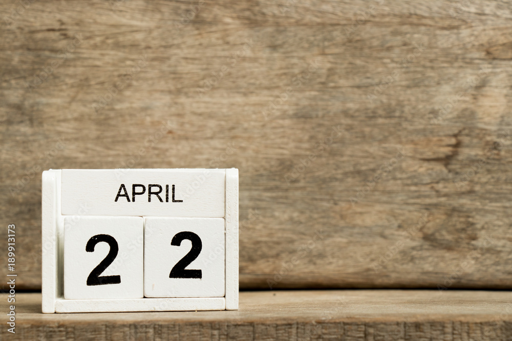 White block calendar present date 22 and month April on wood background White block calendar present date 22 and month April on wood background