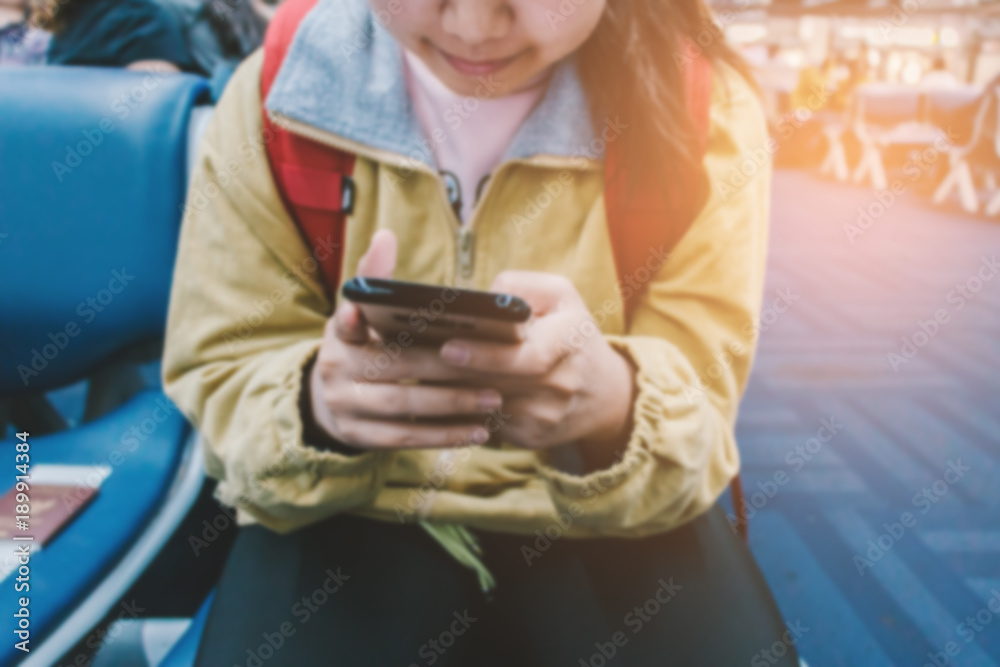 Close up traveler using and typing smartphone between boarding in airport