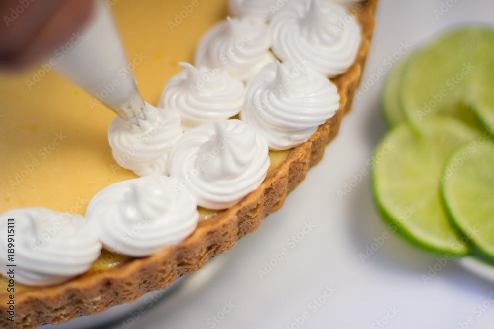 Lemon pie with meringue in decoration process Lemon pie with meringue in decoration process