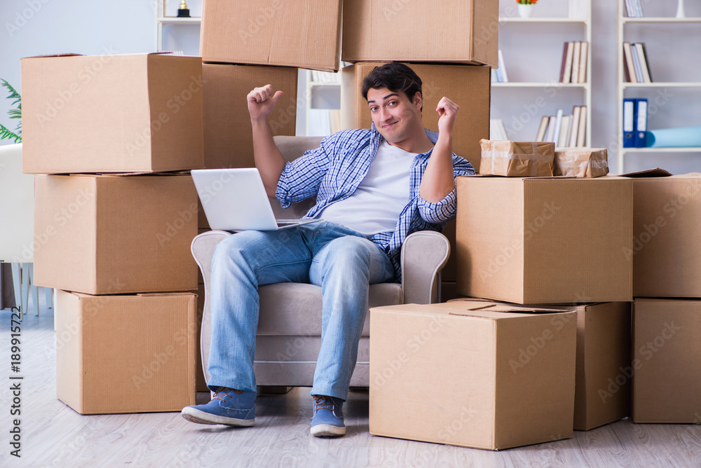 Young man moving in to new house with boxes Young man moving in to new house with boxes