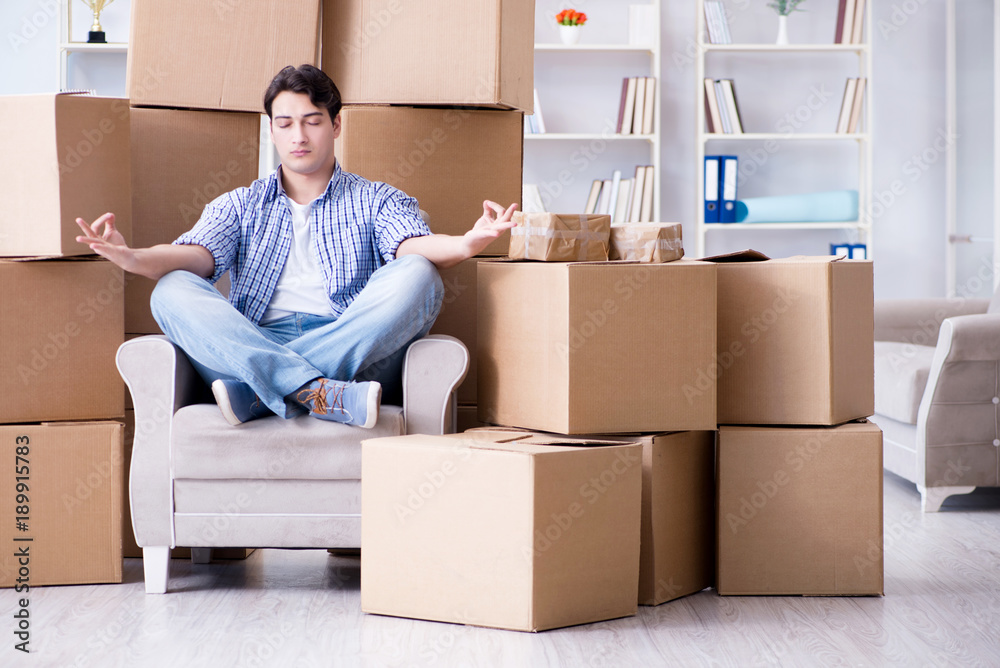 Young man moving in to new house with boxes Young man moving in to new house with boxes