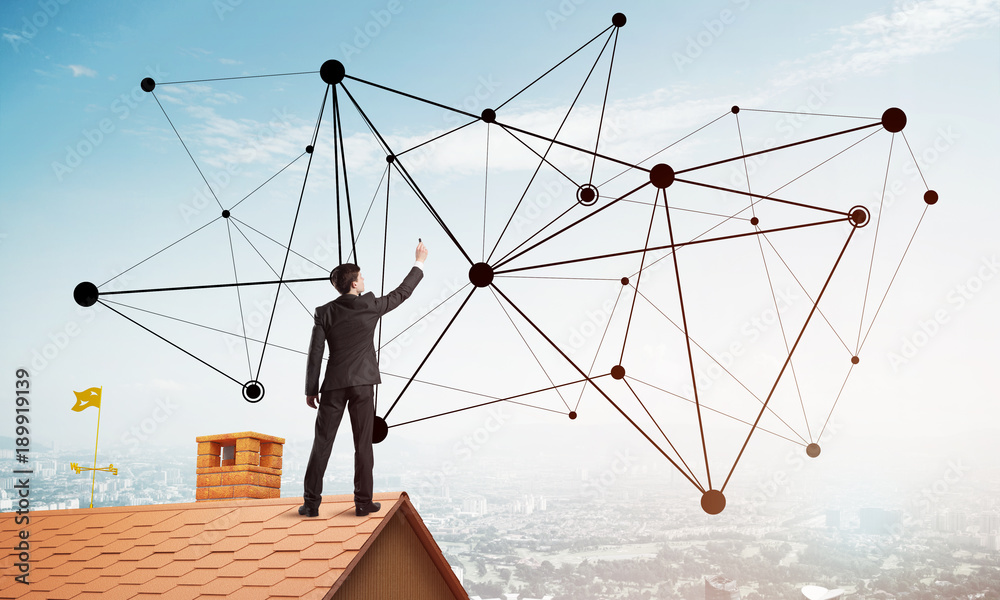 Businessman on house roof presenting networking and connection concept. Mixed media Businessman on house roof presenting networking and connection concept. Mixed media