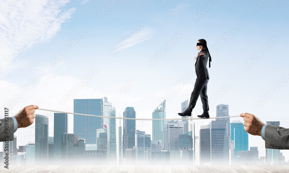 Business concept of risk support and assistance with man balancing on rope Business concept of risk support and assistance with man balancing on rope