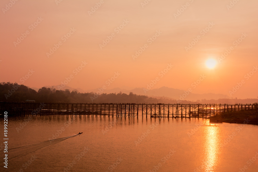 Silhouette old wooden bridge with mountain background and sunlight