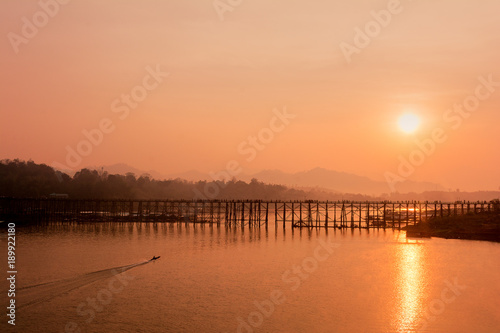 Silhouette old wooden bridge with mountain background and sunlight © elbanco