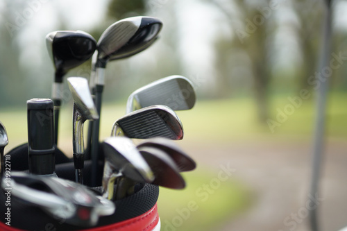 set of golf clubs in a golf bag with fairway background