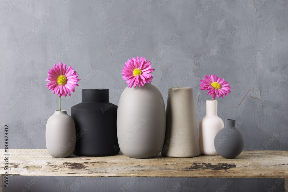 Various vases with flowers on wooden shelf StockFoto Adobe Stock