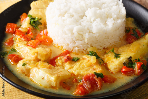 Pescado encocado or fish with coconut sauce is an Ecuadorian coastal dish close-up on a plate. Horizontal