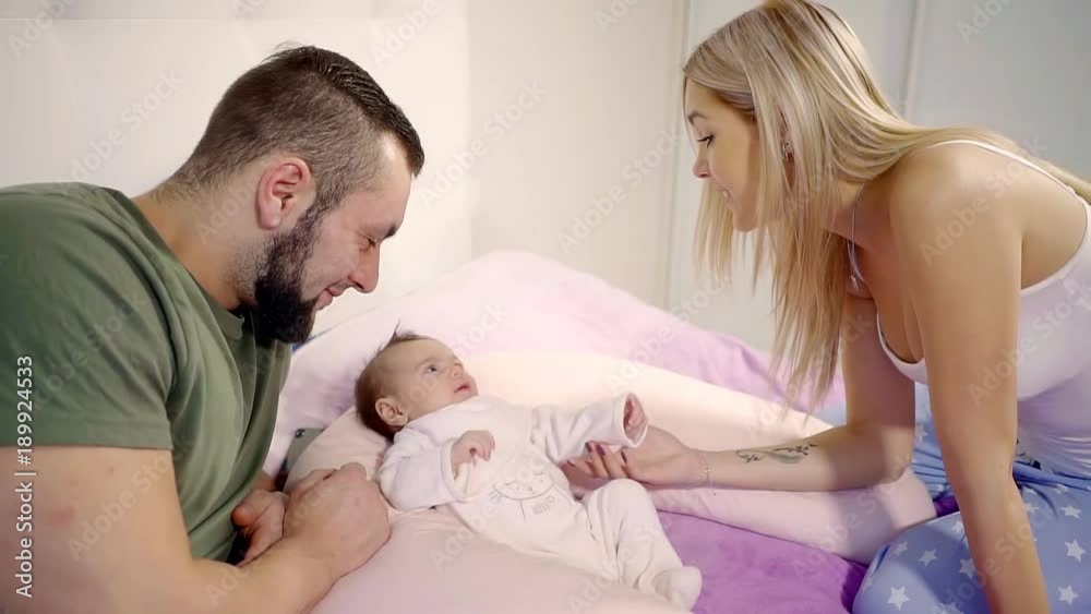 parents spend happy time with their little daughter who lies in the cocoon parents spend happy time with their little daughter who lies in the cocoon