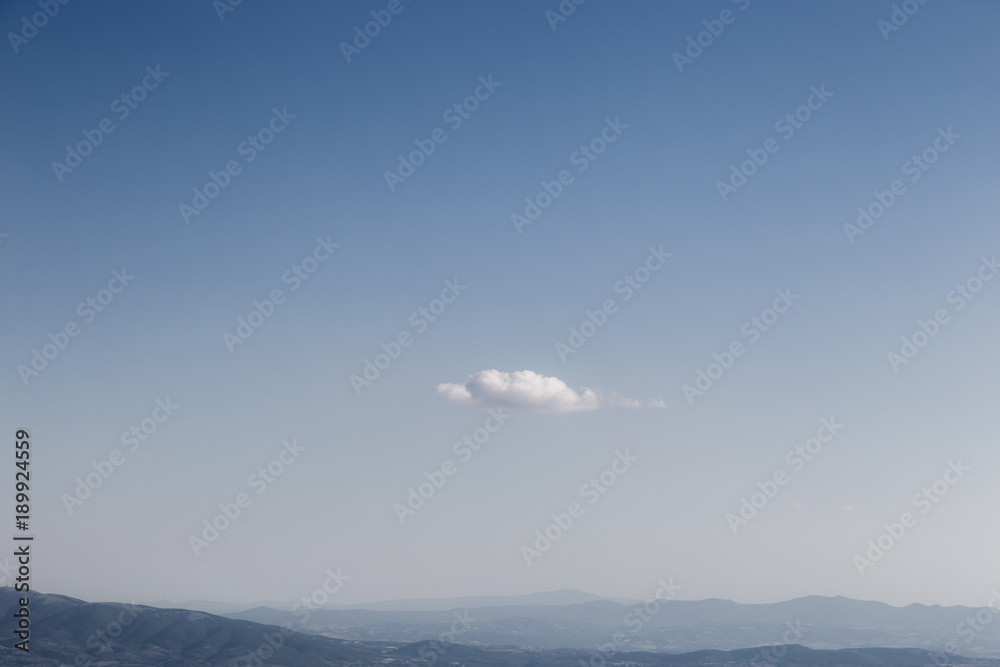 An isolated, little white cloud in an empty blue sky