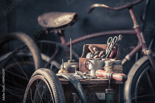 Old bicycle repair workshop with wheels, tools, and rubber patch