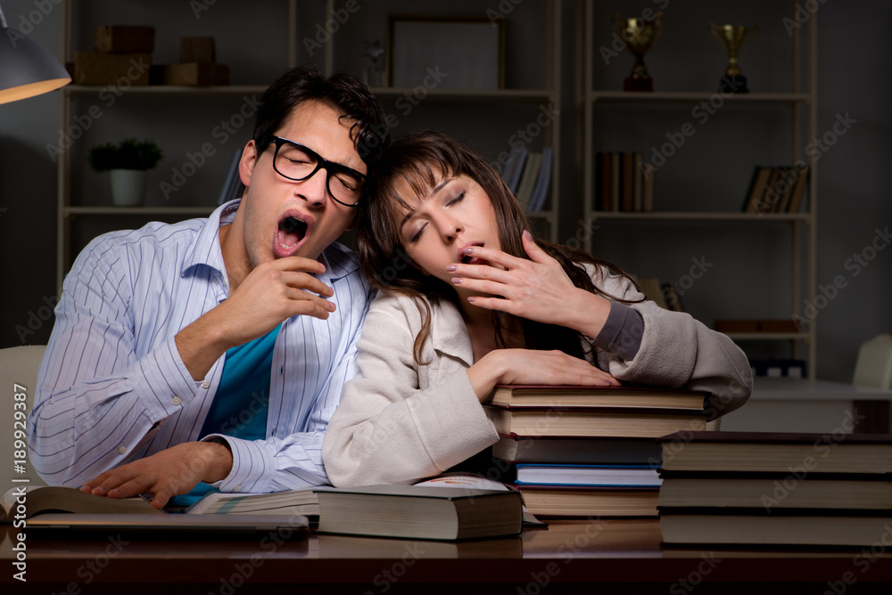 Two students studying late preparing for exams Two students studying late preparing for exams