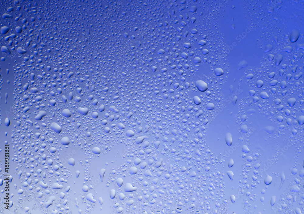 Glass blue texture with water drops on a blue background Glass blue texture with water drops on a blue background