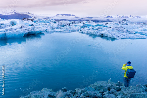 Traveler taking photo of glacier lake