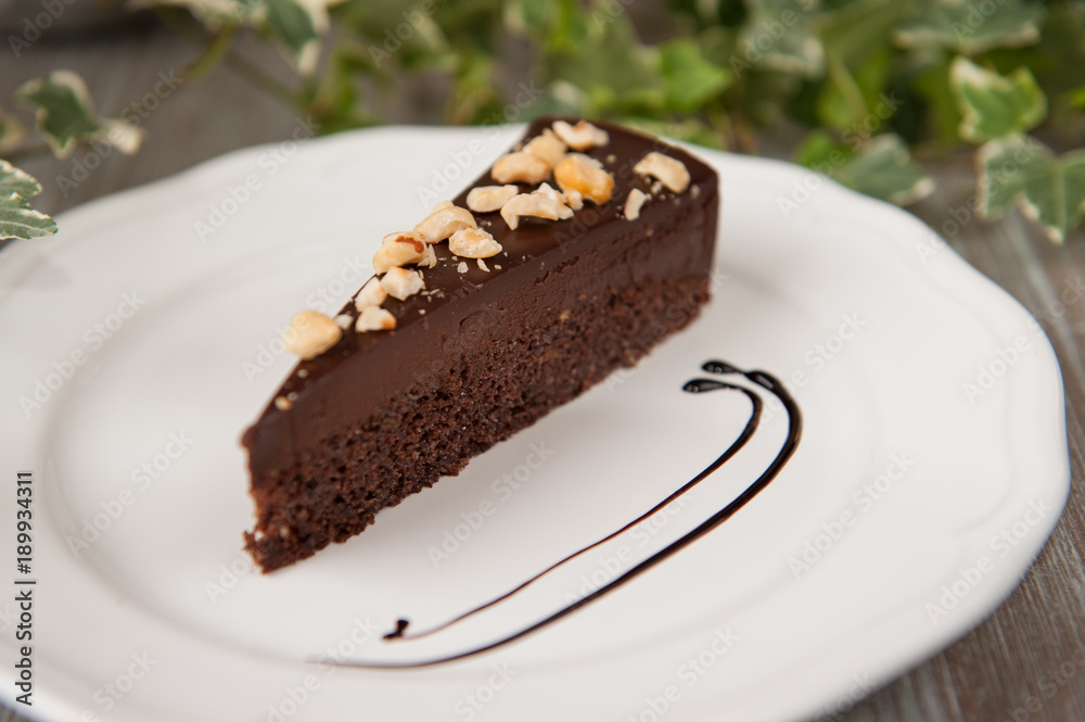 Delicious chocolate cake with almonds on plate on table Delicious chocolate cake with almonds on plate on table