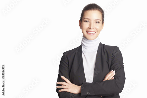 Executive mature businesswoman. A smiling middle aged woman wearing suit while standing with arms crossed and looking at camera at isolated white background. photo