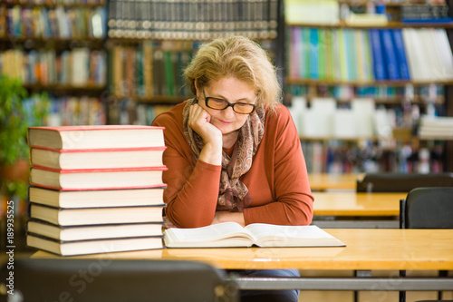 senior woman reading a book in the library
