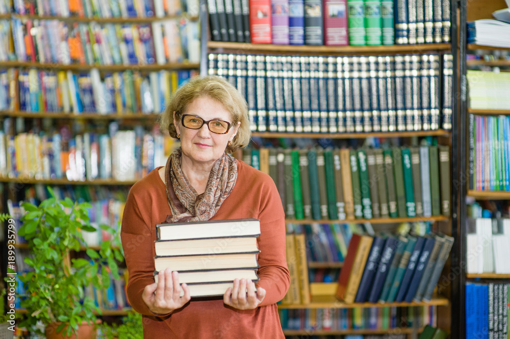 senior woman with books in library senior woman with books in library