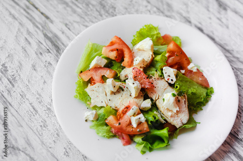 cooking a healthy fresh salad with chicken, grapefruit, cheese and tomatoes