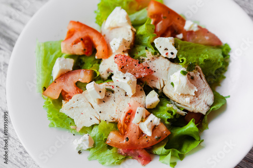 cooking a healthy fresh salad with chicken, grapefruit, cheese and tomatoes