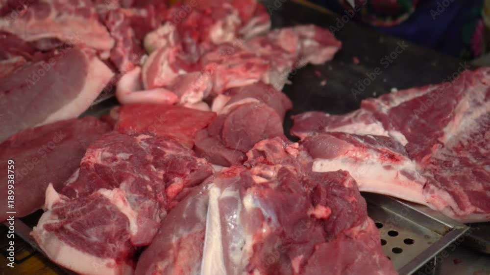 Large number of pieces of crude meat. Counters with meat products. Vietnam. unhygienic meats on ground without ice in asian market Large number of pieces of crude meat. Counters with meat products. Vietnam. unhygienic meats on ground without ice in asian market