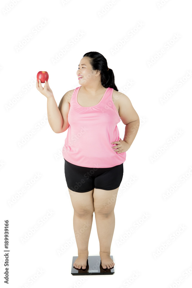 Fat woman with apple and weighing scale Fat woman with apple and weighing scale