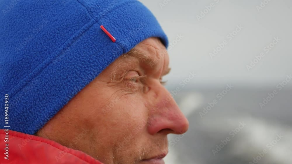 Closeup Face Man With Bright Blue Hat On His Head, Quickly Floating Boat In Sea Closeup Face Man With Bright Blue Hat On His Head, Quickly Floating Boat In Sea