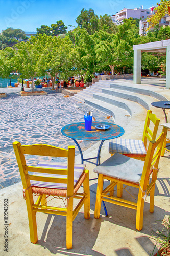 sidewalk cafe with tables and yellow chairs  Crete  Greece