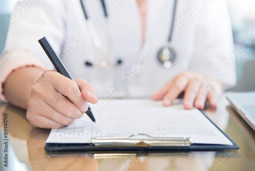 female doctor writing something on clipboard.
