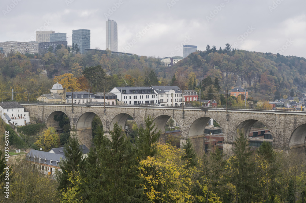 Detail of electrical railroad in Luxembourg city with rails, contact lines and viaduct structures in dark autumn day illustrating urban transport concept, Luxembourg.