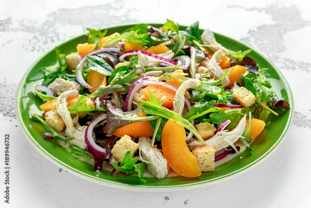 Fresh salad with chicken breast, peach, red onion, croutons and vegetables in a green plate. healthy food Fresh salad with chicken breast, peach, red onion, croutons and vegetables in a green plate. healthy food