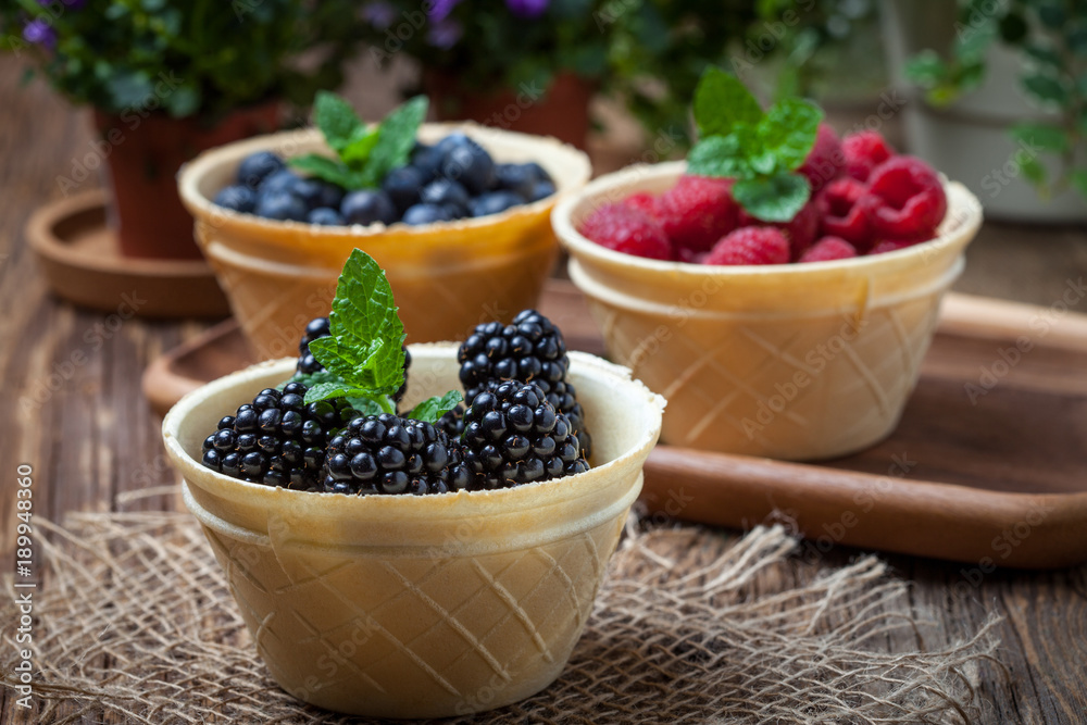 Blackberries, raspberries and blueberries in a waffle bowls. Blackberries, raspberries and blueberries in a waffle bowls.