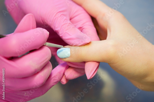 Manicurist painting nails with nail polish