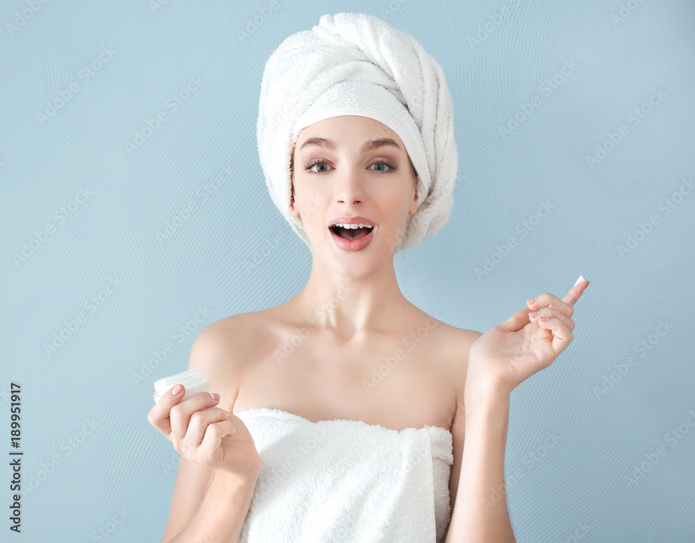 Young woman with jar of hand cream on color background Young woman with jar of hand cream on color background