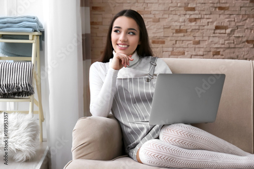Young woman using laptop in...