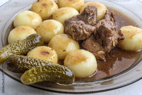 Stewed turkey meat served with silesian dumplings and sauce. photo