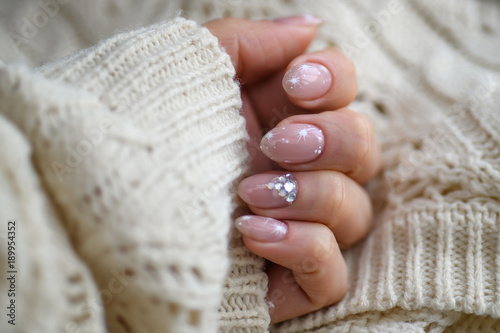 Nail Polish. Art Manicure. Modern style blue Nail Polish.Stylish pastel Color pink white Nails holding wool material sleeve blouse isolated white background wall. Classic wedding bride nails design