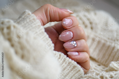 Nail Polish. Art Manicure. Modern style blue Nail Polish.Stylish pastel Color pink white Nails holding wool material sleeve blouse isolated white background wall. Classic wedding bride nails design