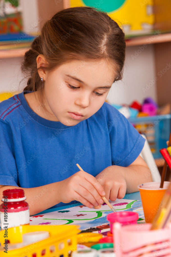 Small students painting in art school class. Child drawing by paints on