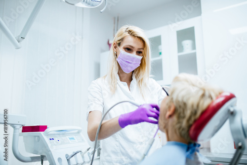 Senior woman having dental treatment at dentist's office. 