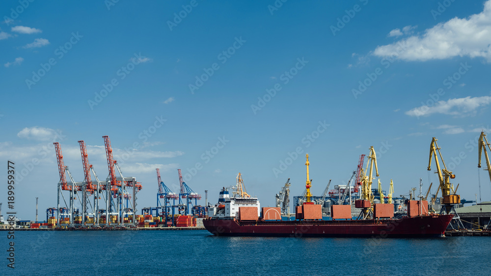 cargo ship stands in an industrial port on a sunny day