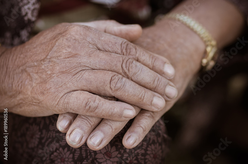 Slika na platnu Hands Asian elderly woman grasps her hand on lap, pair of elderly wrinkled hands and Traces of hard work, World Kindness older and Adult care  concept