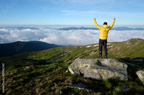 Alone tourist in yellow jacket sitting on rock on high mountains. © Ivan Kmit